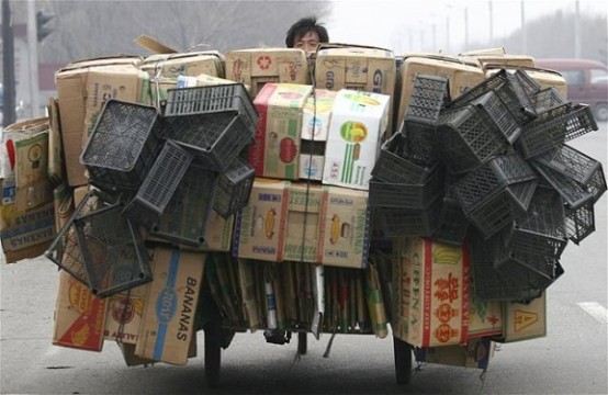 Çin’in Shenyang şehrinde taşıdığı çeşitli kutular yüzünden bisikleti neredeyse orada değilmiş gibi görünen bir adam.