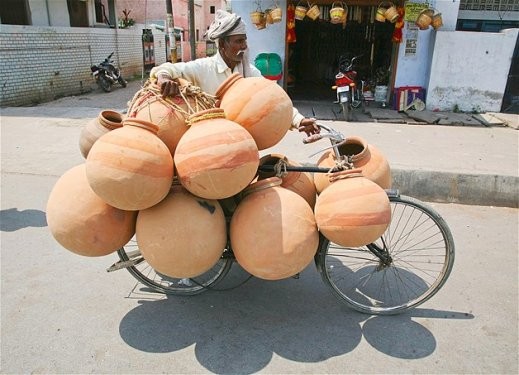 Hindistan’ın Allahabad şehrindeki pazarda satmak üzere çömleklerini taşıyan bir adam.