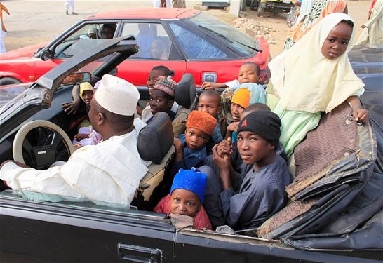Nijerya’da bir araba dolusu çocuk taşıyan adam.